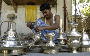 An artisan working carving on brass lamp at NachiyarKoil Nachiyar Koil near Thanjavur Tanjore