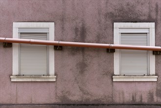 Drain pipe runs across the windows of a single-family house