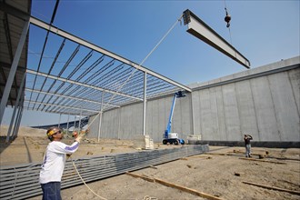 Steel Workers and Warehouse Construction with Prefabricated Concrete & Steel