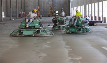 Riding Power Trowels over freshly poured concrete can smooth the surface to a glasslike finish