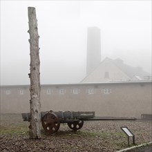 Stake and cart with crematorium in the fog at beech forest concentration camp