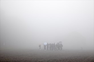 Group of visitors in the fog at beech forest concentration camp