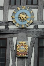 City coat of arms and golden clock on the historic town hall in Michelstadt