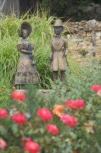 Biedermeier couple with red roses in the rose garden in Eiltville