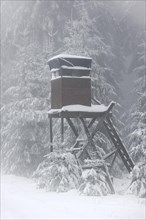 Raised stand for hunting in forest in the snow in winter