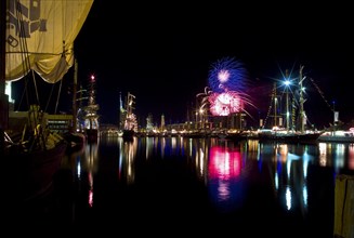 Tall ship at night in the harbour with fireworks