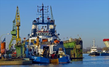 The tug Fairplay 33 in front of a floating dock at Lloyd Werft. Bremerhaven. Germany