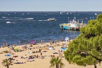 People on the beach of Arcachon and boats in the bay of Arcachon