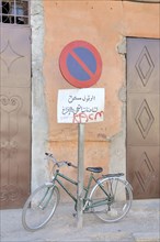 Bicycle tied to a no parking sign