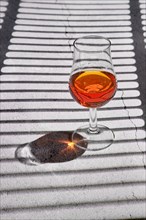 Glass of brandy on concrete background