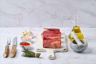 Fresh raw beef eye of round steak on white wooden cutting board