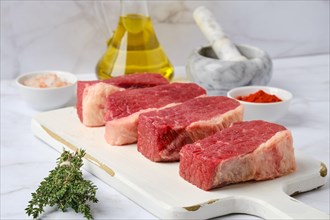 Closeup view of raw beef brisket flat steak on white wooden cutting board