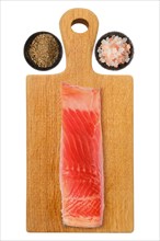 Piece of salmon fillet on wooden cutting board with salt and pepper