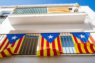 Three independentist flags known as Esteladas hanging from the balcony of a house in a town on the Costa Brava in the province of Gerona in Catalonia Spain