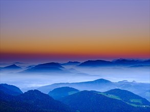 Silhouette of the Osterhorn group with haze in the valleys at dusk