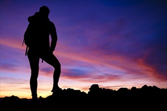 Silhouette of a female mountaineer at dawn