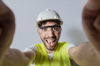 Smiling male engineer taking a selfie looking at camera. Funny builder engineer taking a selfie isolated