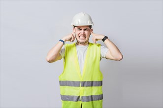 Young engineer covering his ears isolated