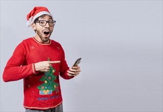 Guy pointing at christmas promotion on phone. Online Christmas special offers concept