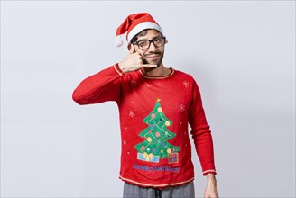People in Christmas clothes making a call gesture with their fingers. Man in christmas hat imitating a phone conversation