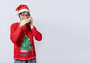Man in christmas hat talking on the phone secretly. Christmas guy talking on the phone secretly