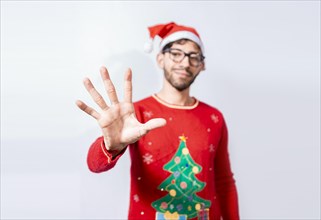 Man in christmas hat counting number five with fingers. Man in christmas costume counting number five with fingers. Concept of man in christmas costume counting number five isolated