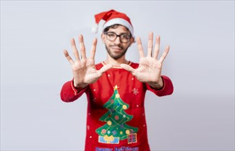 Man in christmas hat counting number ten with fingers. Christmas young man counting number ten with hands. Concept of man in christmas costume counting number ten isolated