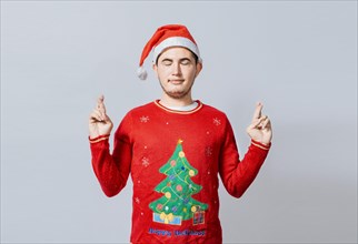 Hopeful man in christmas clothes making a wish