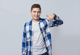 Smiling guy pointing down with one hand isolated