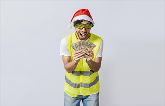 Builder engineer in christmas hat with happy expression holding dollars isolated. Concept of engineer with money in holiday season