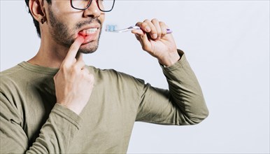 People holding toothbrush with gum pain. Man holding toothbrush with gum pain