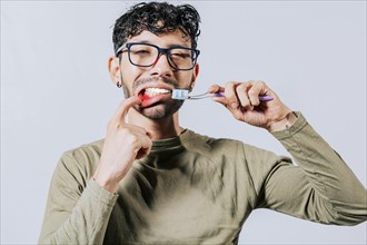 Man holding toothbrush with gum pain