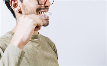 Face of person brushing teeth isolated with copy space. Man brushing his teeth isolated