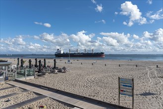 Cargo ship cruising in front of the beach at Boulevard Evertsen