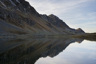 Mountains reflected in Lake Schotten in autumn on the Flueela Pass