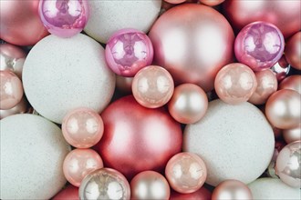 Top view of various pink and white Christmas tree ornament baubles