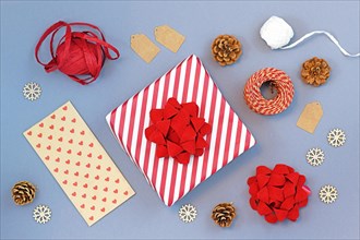 Seasonal christmas flat lay with red and white striped gift box with big ribbon