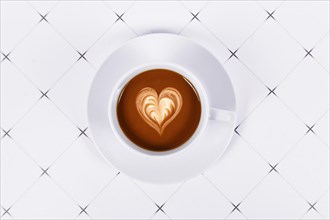 Top view of cup of cocoa with heart shaped milk coffee art