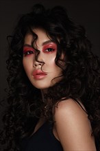 Portrait of a beautiful asian woman with red makeup and curls. Beauty face.Photo taken in studio
