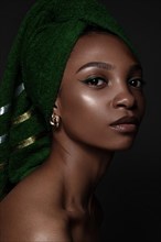 Beautiful black woman with a green towel on her head and classic make-up. Beauty face. Photo taken in the studio