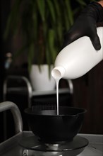 The hairdresser kneads the hair dye in the salon. Hair coloring process