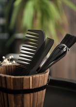 Hairdressing tools combs close-up in a wooden vase. Close up
