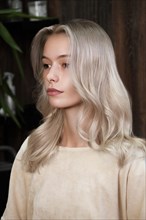 Young woman in a hairdressing salon dyes her hair blond. beauty face and hair