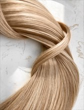 A strand of blond hair on a white background. Close-up