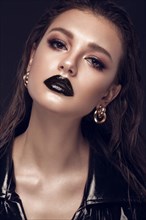 Beautiful girl with black creative art make-up and gold accessories. Beauty face. Photos shot in studio