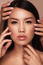 Beautiful delicate woman of oriental type with nude makeup and perfect skin. Beauty face. Spa salon