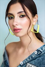 Beautiful girl with bright fashionable make-up and unusual yellow accessories. Beauty face. Photo taken in the studio