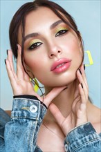 Beautiful girl with bright fashionable make-up and unusual yellow accessories. Beauty face. Photo taken in the studio