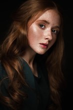 Beautiful Redhead girl with a perfectly curls hair and classic make-up. Beauty face. Picture taken in the studio