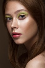 Beautiful red-hair girl with creative green makeup. Beauty face. Photos shot in studio
